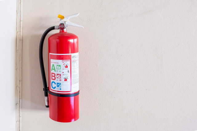 a ABC fire extinguisher hanging on a wall