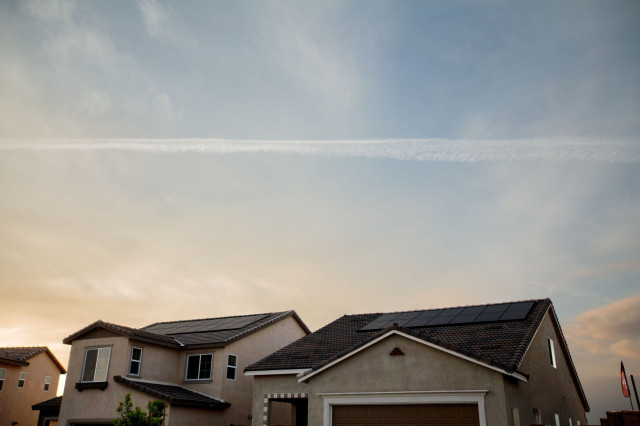 a home at dusk with solar panels on its roof