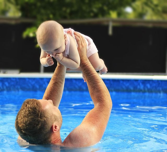 Father holding child in pool - safety