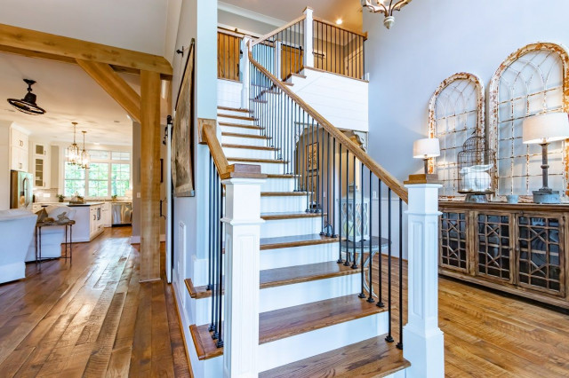 a wooden staircase in a white and wooden accented living room