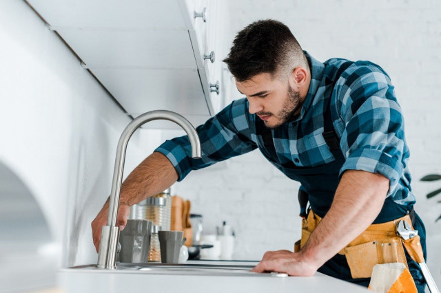 man standing by sink and faucet