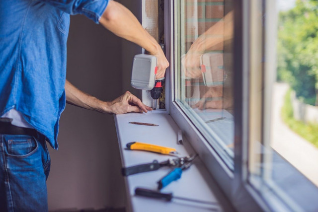 man working with tools on windowsill