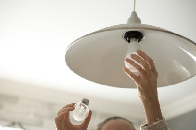 homeowner changing light bulb