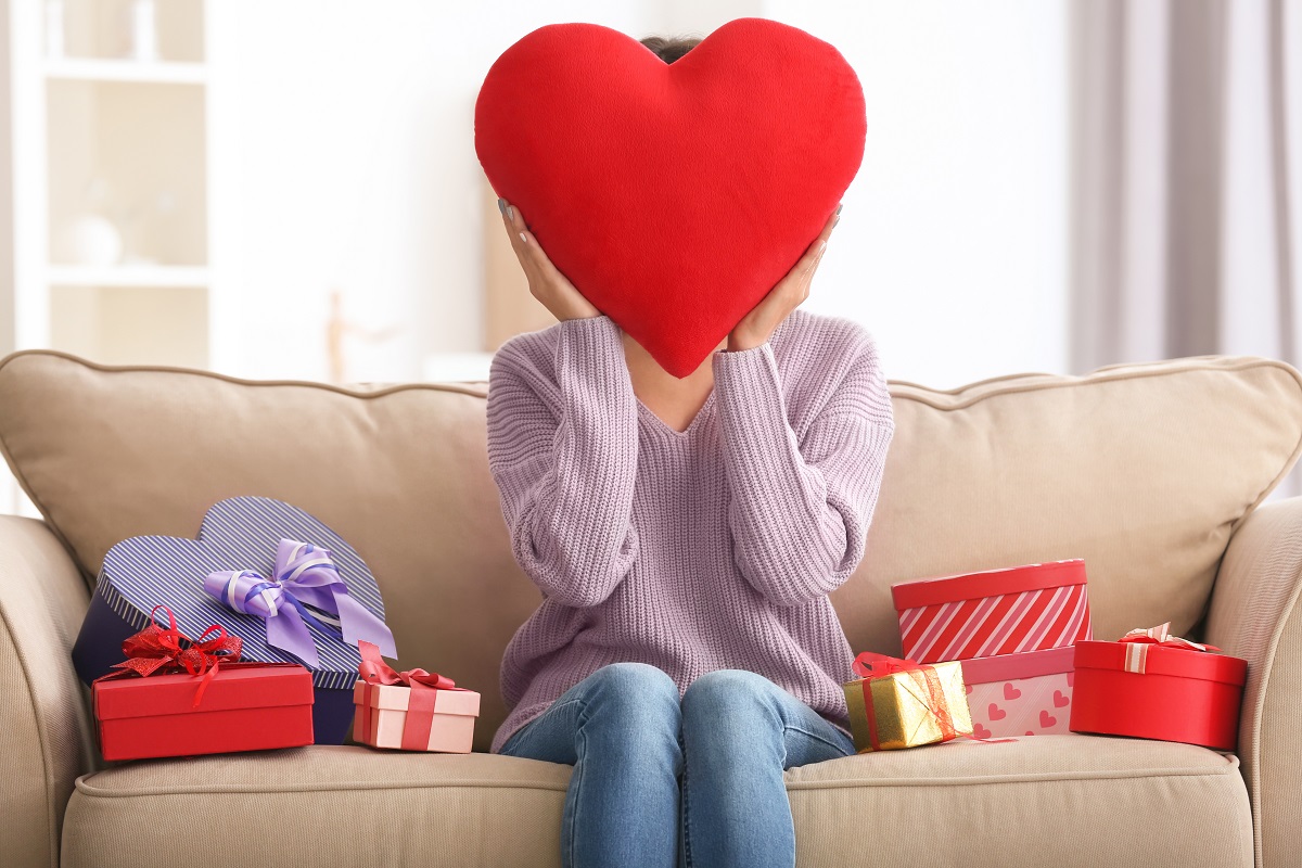 Woman with hear pillow held in front of her face