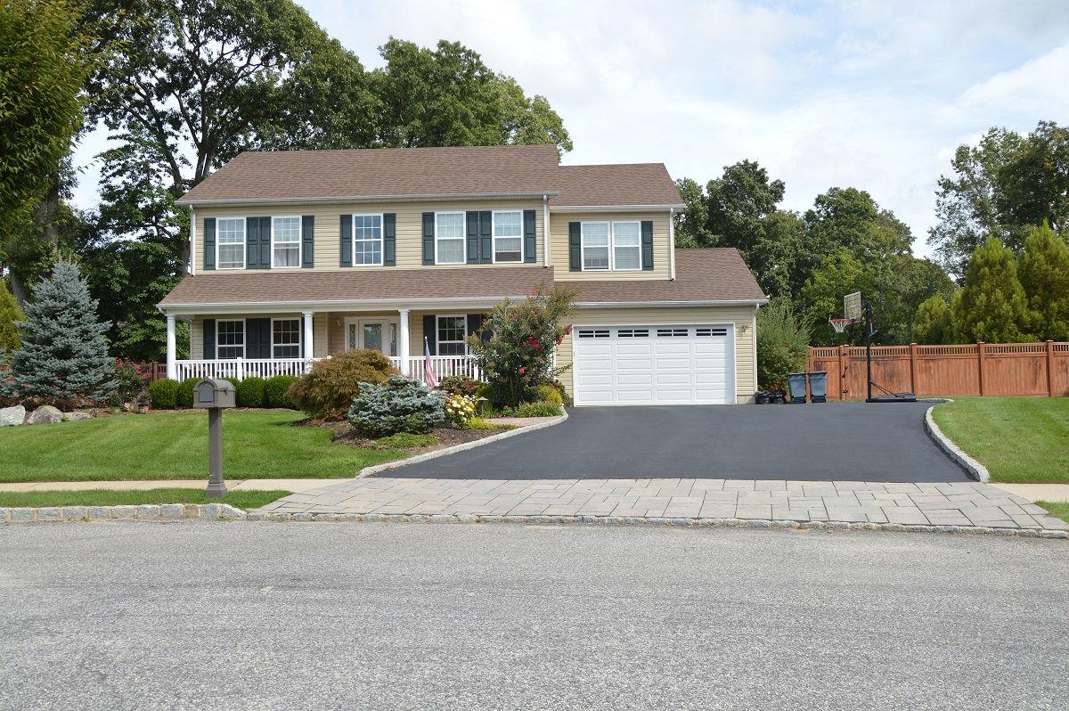 colonial home with newly paved driveway