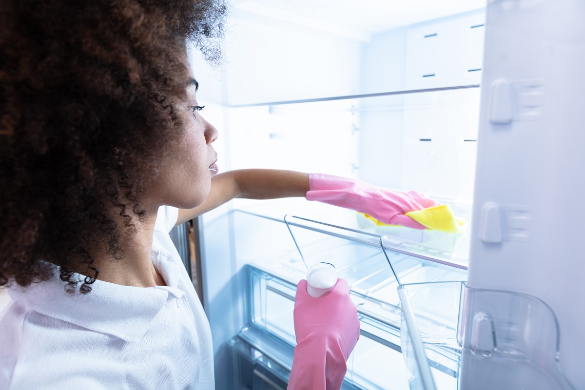 woman washing a fridge door
