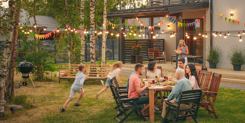 family outside enjoying a meal under edison bulb lights