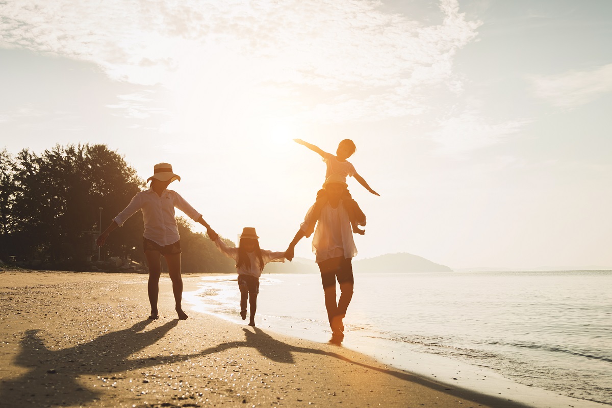 family walking on a beach near the water