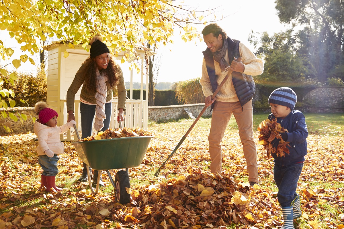 family raking up leaves together