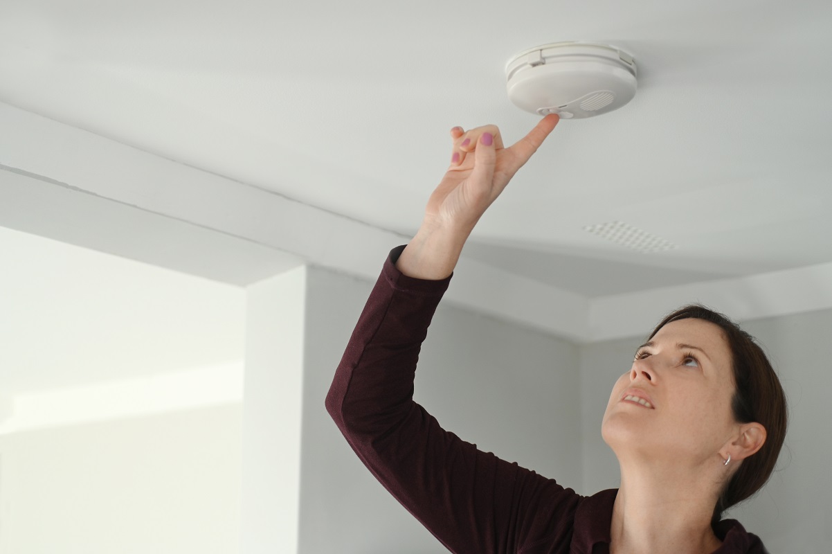 woman testing a smoke detector