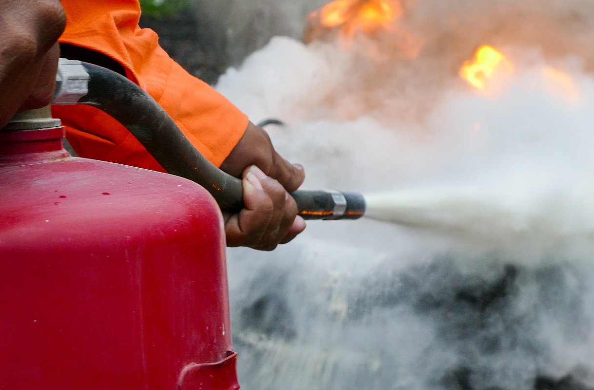 a firefighter using a fire extinguisher