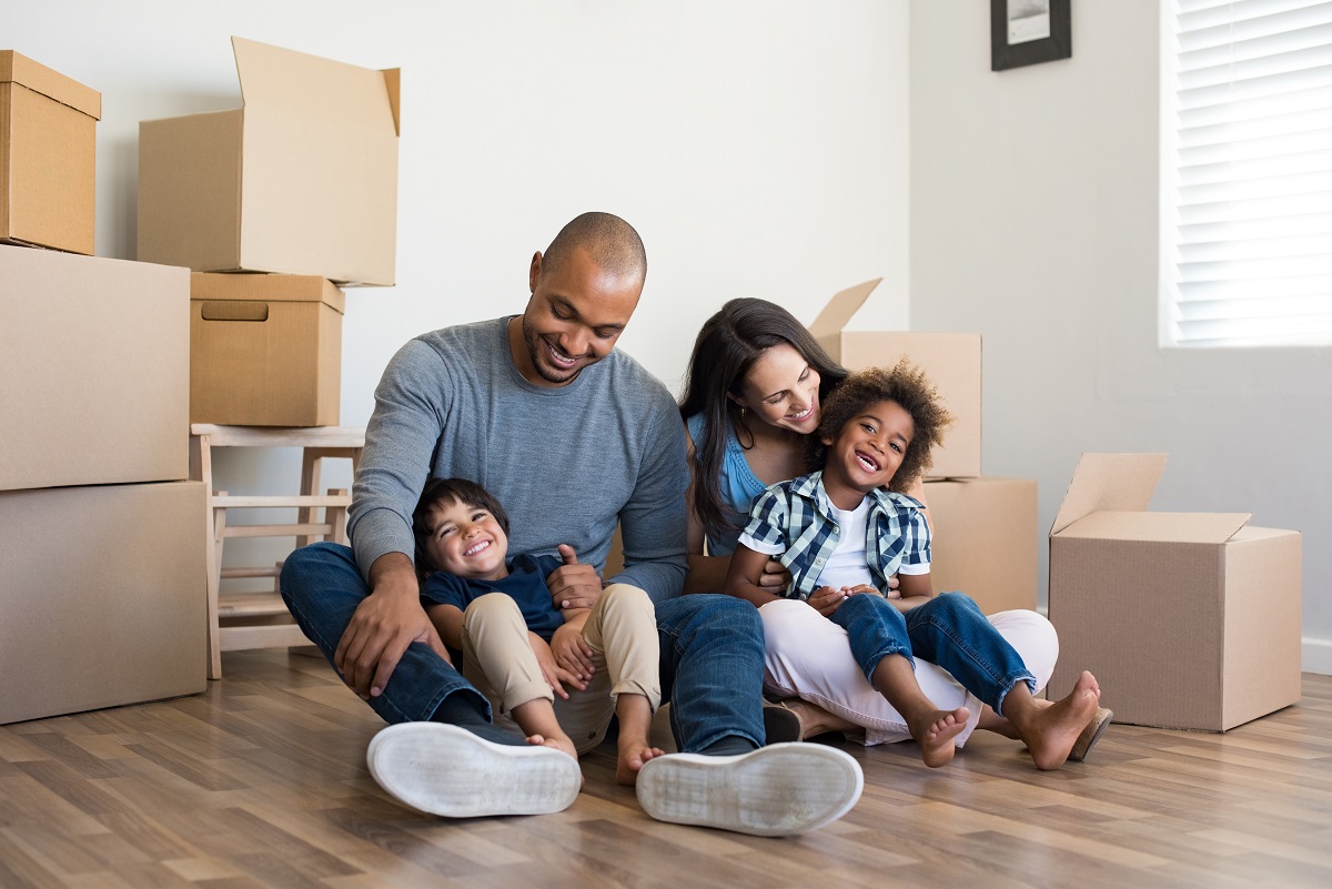 family sitting in front of a room full of moving boxes