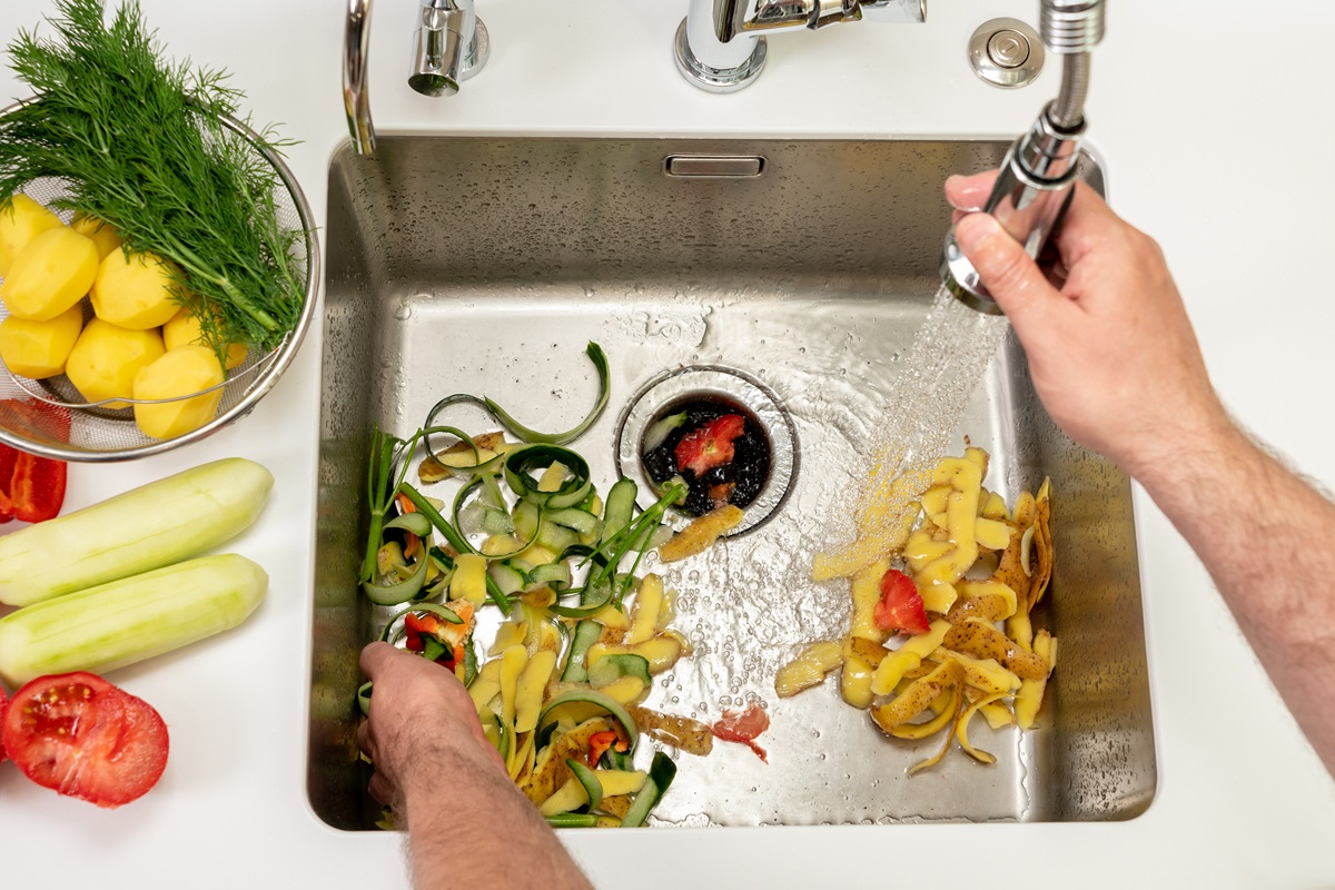 Working kitchen disposer on a modern sink to remove food waste.