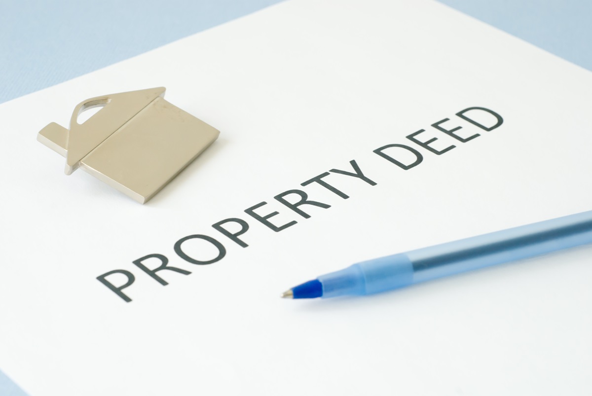 a picture of a house on a piece of paper; the words property deed are typed on the paper