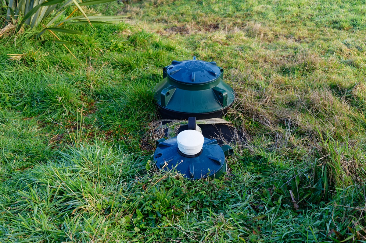 A septic tank system is showing through the grass