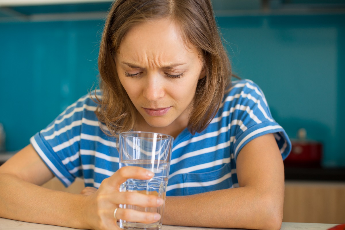 A woman looking down at a glass of water