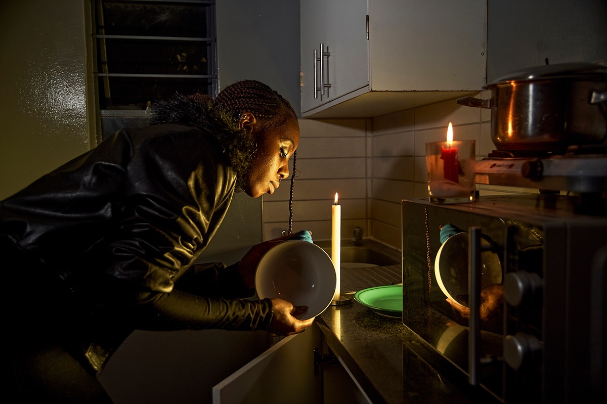 a power ouatage, woman in the kitchen near candle