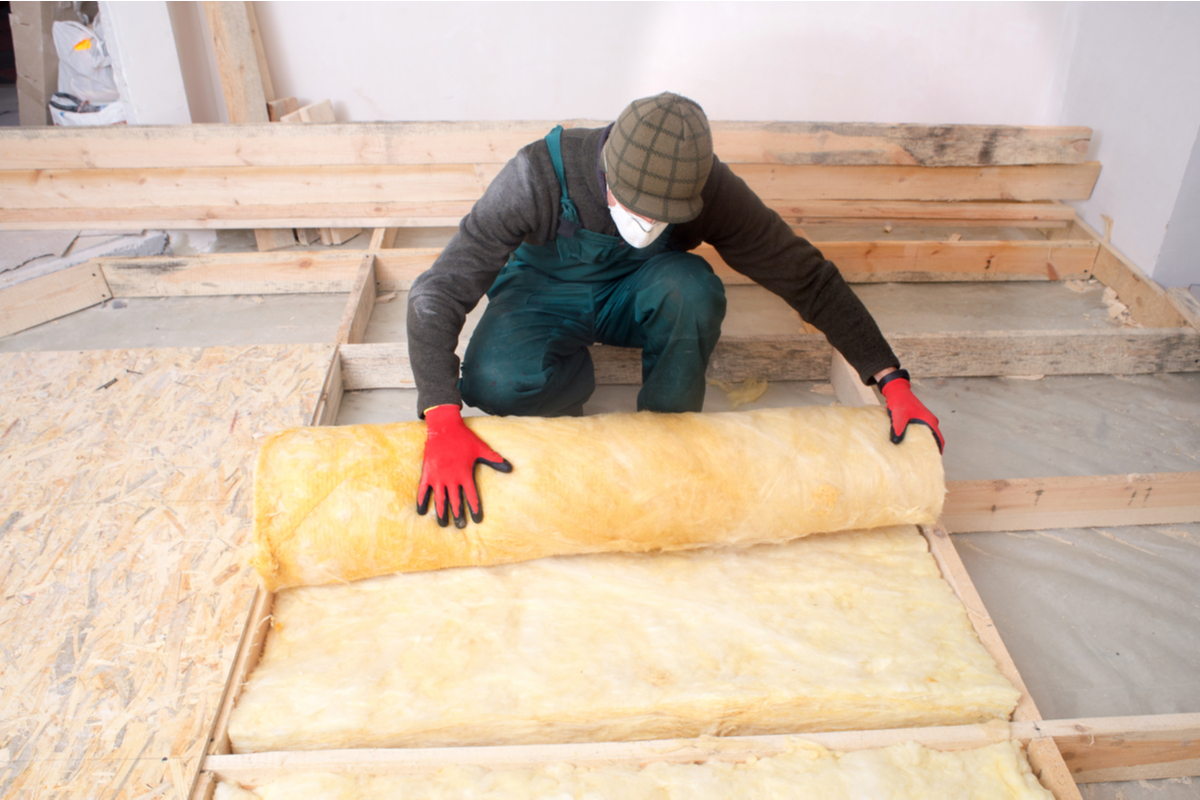 a professional rolling out insulation