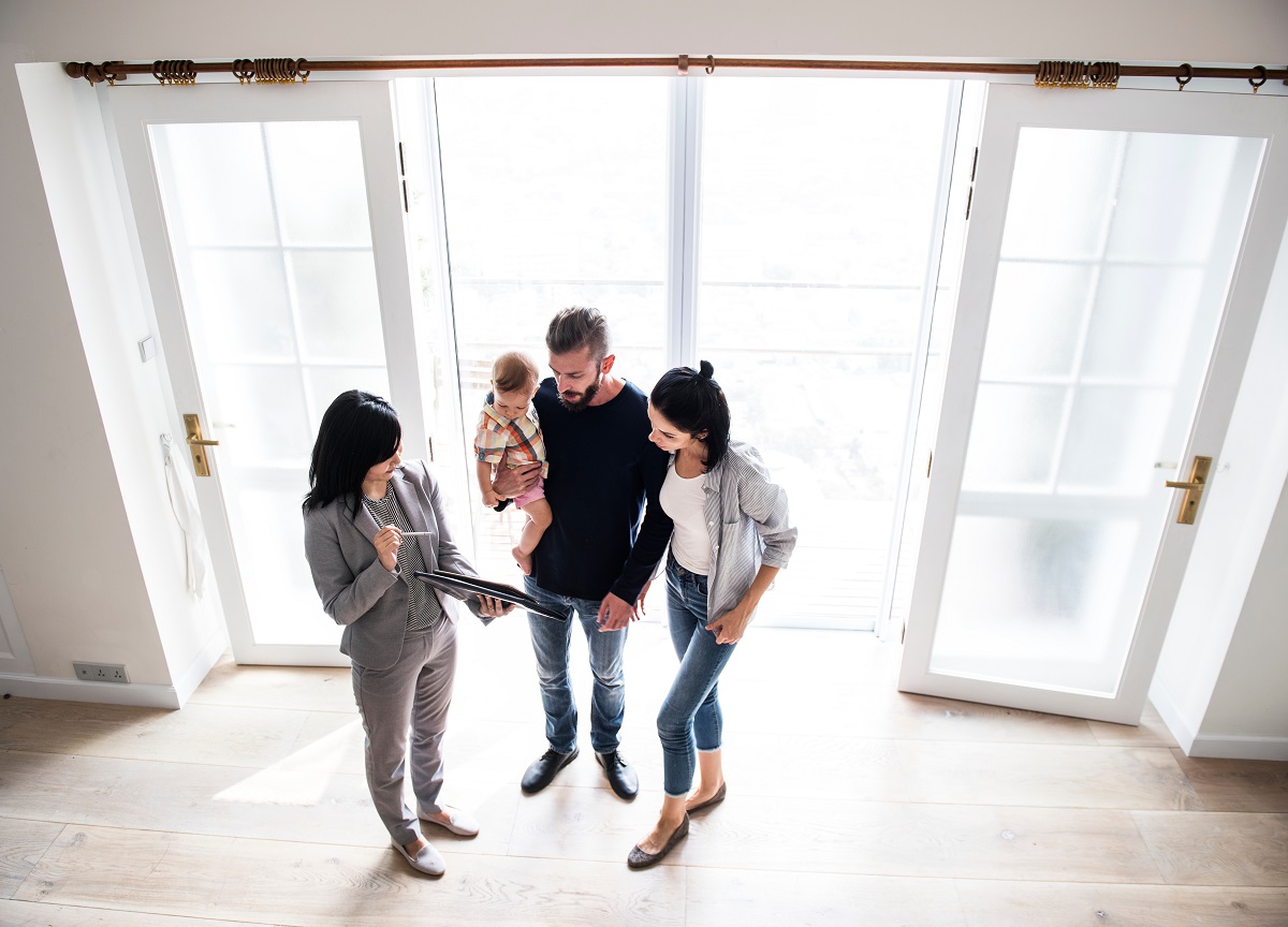 a couple and their child talking to a realtor in a home
