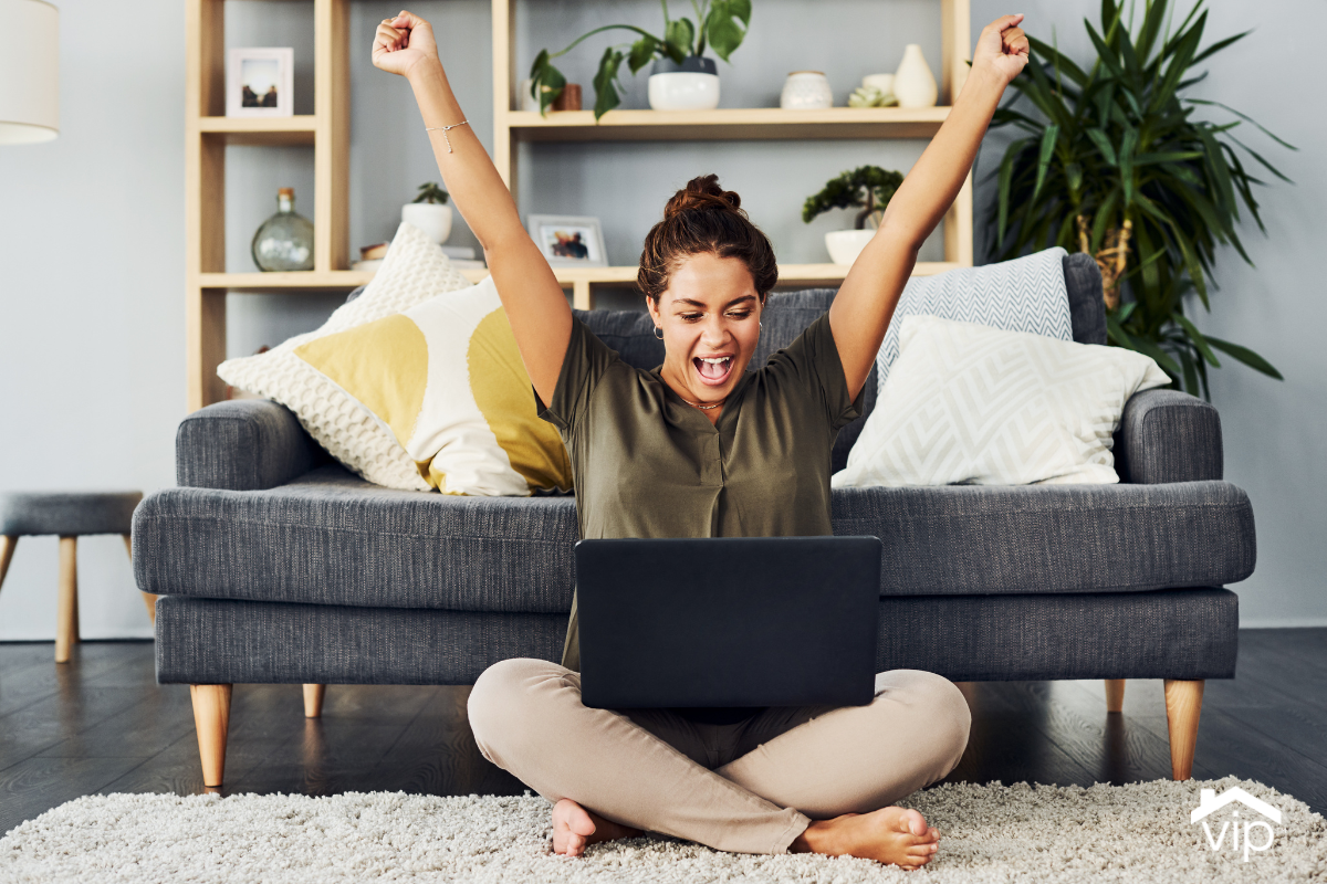 a woman sitting cross-legged on the ground in front of her couch, cheering